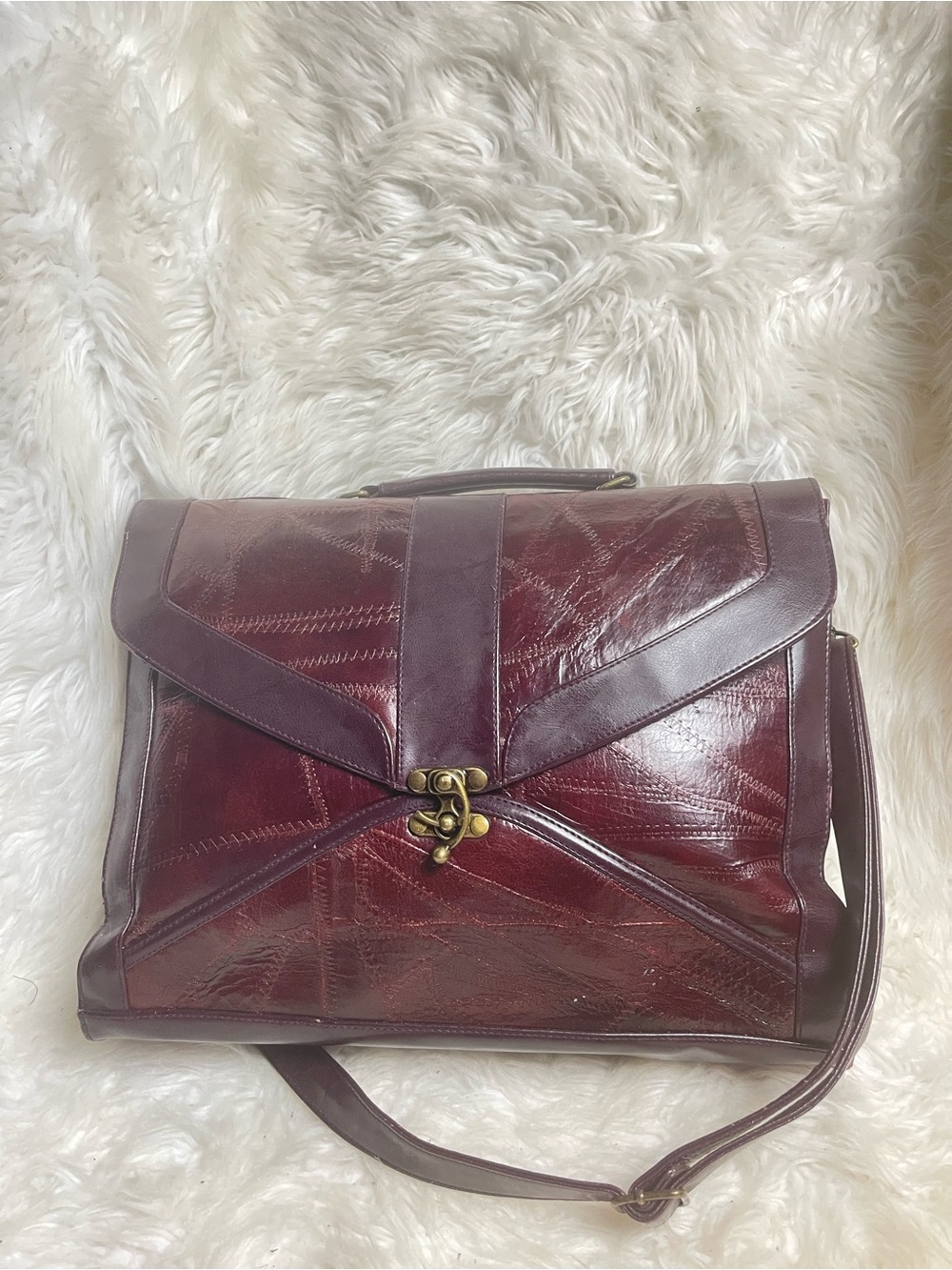 M.C textured leather patchwork like stitched accent burgundy leather bag .